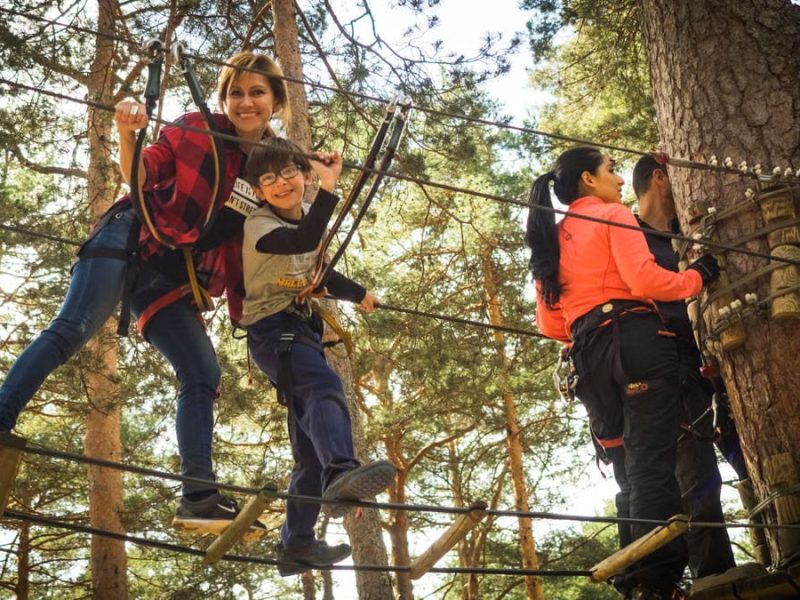 A family enjoys a thrilling day on a ropes course in Cercedilla, Spain.