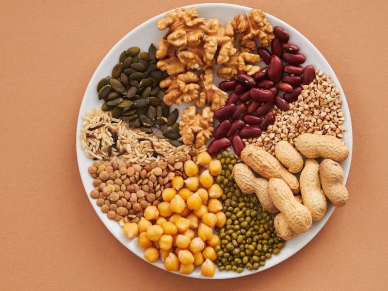 Top view of nuts, beans, and seeds on a plate, ideal for healthy dining themes.